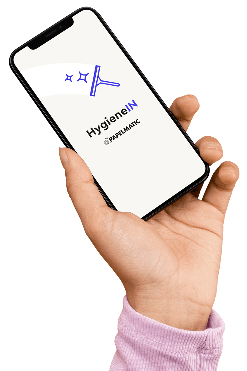 Mano sujetando un teléfono móvil en el que puede verse la aplicación de HygieneIN